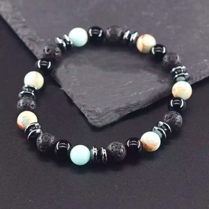 Detailed view of 8mm natural lava rock and tiger eye beaded bracelet on stone surface