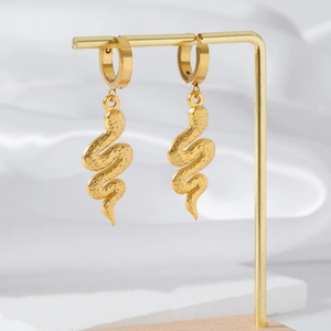 Detailed close-up of 18K gold snake drop earrings with a textured hammered metal finish