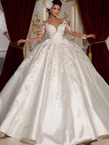 Detailed close-up of luxury bridal gown featuring intricate lace embroidery and satin fabric