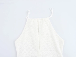 Detail of white halter neck knit dress featuring textured diamond pattern and drawstring