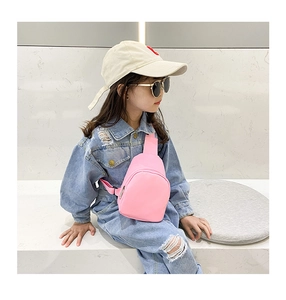 Detail of pink toddler crossbody bag with adjustable strap and zipper on denim outfit