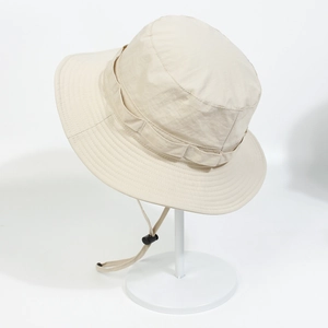 Detail showing the adjustable windproof drawstring and secure buckle on a beige sun hat