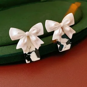 Elegant white bow earrings with black and white marbled geometric drop on velvet box