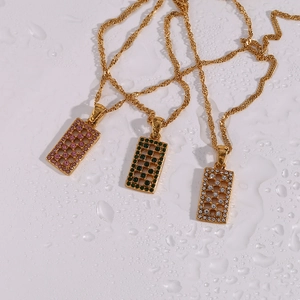 Macro shot of rectangular hollow pendants with colorful zircons on gold rope chains
