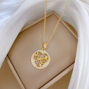 Close-up of golden necklace with Mom pendant and star zircons in a soft gift box