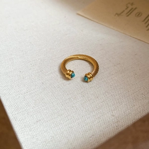 Macro detail of 18k gold plated cable twist open ring with blue turquoise stones