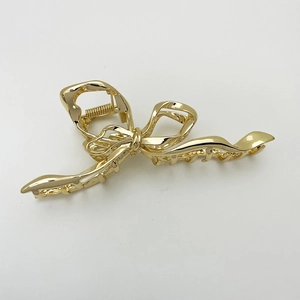 Close-up of a large gold metal butterfly hair claw clip with a glossy polished finish