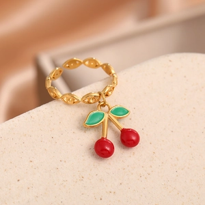 Detailed macro view of the gold cherry pendant ring with red and green enamel coating