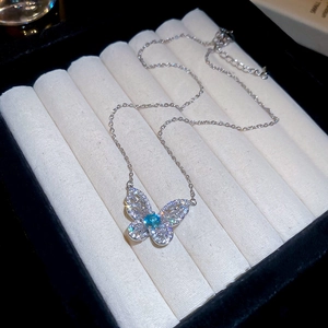 Detail shot of a silver butterfly necklace with blue stone and pavé zircon stones