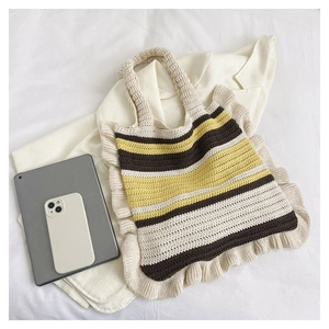 Detail of hand-crocheted striped tote bag with ruffles, shown with a tablet for size
