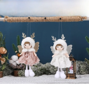 Detail of Christmas angel girl ornaments with lace dresses and pearl collars on a snowy background