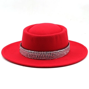 Dettaglio di un cappello di lana rossa con fascia di lusso in cristalli strass multifila
