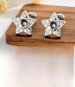 Detailed view of silver star ear studs with zircons and screw back design