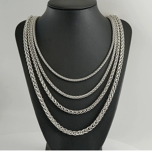 Detail view of four silver braided wheat chains in tiered lengths on a black bust