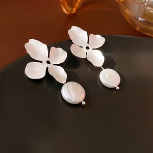 Detail of silver brushed metal flower earrings with white irregular freshwater pearls