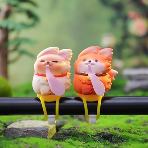 Détail de mignonnes figurines de renard beige et orange pour guidon de vélo ou scooter