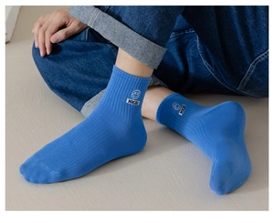 Close-up of blue cotton rib-knit socks featuring white NICE! smiley face embroidery