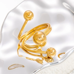 Macro detail of a 18k gold spiral ring with sphere ornaments on a reflective base