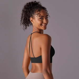 Detail of black halter yoga bra with thin Y-back crossover straps on a model