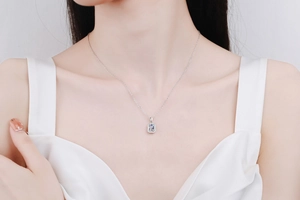 Close-up of a Radiant cut Moissanite pendant necklace on a woman's neckline