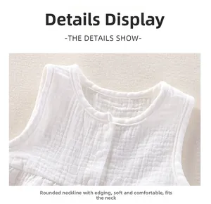 Detail of baby white cotton gauze vest showing soft texture and snap buttons on neckline