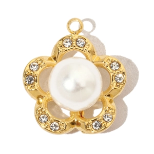 Macro shot of gold floral charm with a central white pearl and sparkling rhinestones