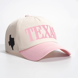 Detail view of the pink Texas embroidery and state map outline on a cream baseball cap