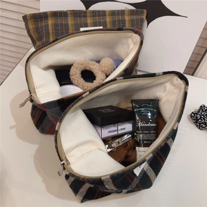Macro view of British plaid cotton makeup bag with silver metal zipper and inner lining