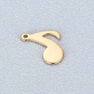 Macro shot of gold music note pendant with polished finish and circular bail attachment