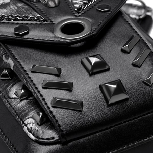Close-up of black punk bag featuring metallic pyramid studs and industrial eyelet details