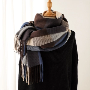 Detailed close-up of thick plaid scarf with tassels on a mannequin for winter warmth