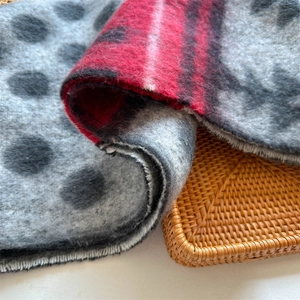 Detail of soft gray cashmere-like scarf featuring black polka dots and red plaid patterns