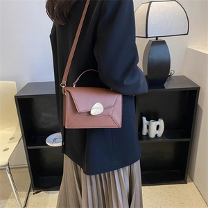 Minimalist brown leather crossbody bag with vintage gold buckle and top handle for women
