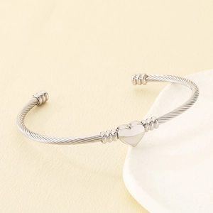 Vue détaillée du bracelet jonc en fil d'acier argenté en forme de cœur texturé