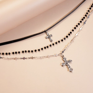 Detail of gothic triple-layer choker with black leather, beads, and silver cross pendants