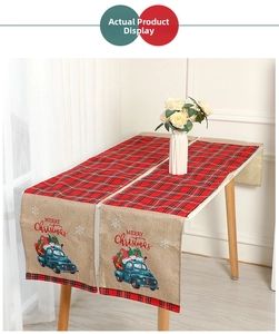 Close-up of linen Christmas table runner featuring blue vintage truck and red plaid pattern