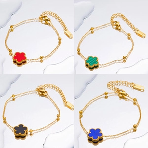 Macro view of gold flower charm bracelets in red, green, black and blue colors