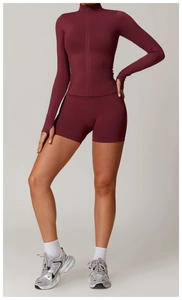 Detail view of burgundy yoga jacket with stand collar, zipper, and thumbhole cuffs