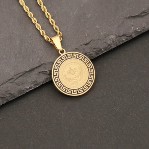 Macro detail of gold stainless steel necklace with Greek fret pattern and eagle crest