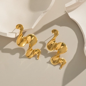 Macro shot of 18K gold plated spiral earrings on artistic stone pieces