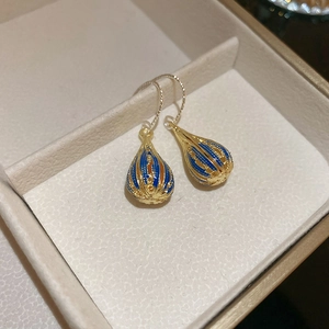 Detail of vintage Bohemian drop earrings with colorful enamel inside a jewelry box