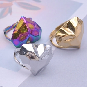 Detail of three geometric heart rings in rainbow, gold, and silver polished metal finishes