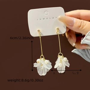 Detail view of long white petal earrings with pearls including size and weight measurements