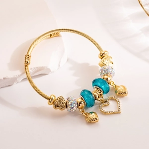 Golden twisted bangle with blue glass beads and sparkling heart charms with LOVE engraving