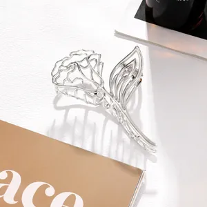 Close-up of elegant silver hollow rose metal hair claw clip with 3D floral details