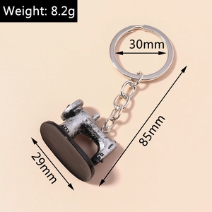 Detailed view of vintage silver sewing machine keychain with 8.2g weight marking