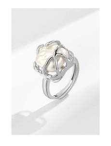 Detailed macro shot of an elegant silver pearl ring with a baroque white pearl focus