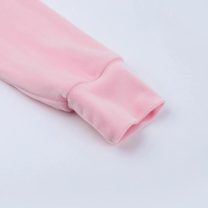 Dettaglio del polsino a coste della manica di una felpa in velluto rosa con texture