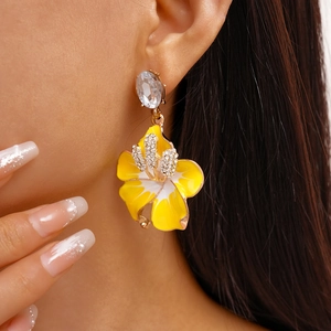 Macro di orecchini a fiore in smalto giallo con strass scintillanti su modella