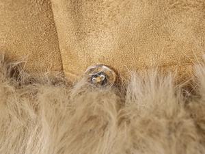 Detail of camel faux suede fabric with soft faux fur trim and a clear round button